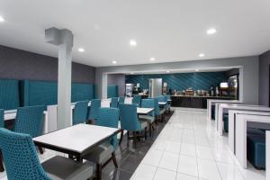 a dining room with tables and chairs and a bar at Clarion Pointe in Charlotte