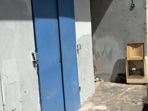 an empty room with a blue door and a box at kolaille chambre HOTE numéro 42 in Saint-Pierre