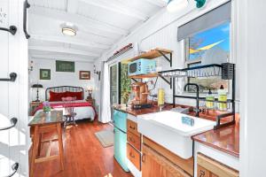 a kitchen with a sink and a bed in a room at Caboose on the Square in Wimberley