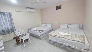 a room with two beds and a chair in it at hotel Mansion grand in Khammam