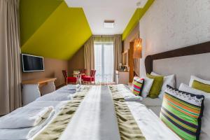 a hotel room with a large bed and a table at Hotel Piwniczna SPA&Conference in Piwniczna-Zdrój