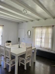 a dining room with a table and chairs and a bed at La casita in Saladillo