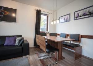 ein Wohnzimmer mit Tisch und Stühlen und einer Couch in der Unterkunft Welcome in - Appartement met parking & skiberging, terras, centraal gelegen in Winterberg