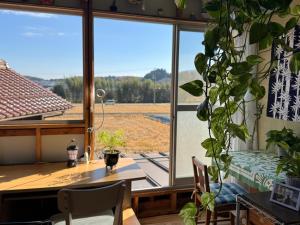 a dining room with a table and a large window at Blue Art Satoyama Retreat in Ōasa +53 photos