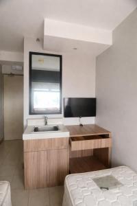 a bathroom with a sink and a mirror and a bed at Isaiah CityScape in Manila