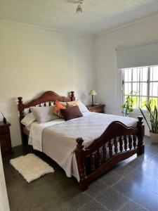 a bedroom with a large wooden bed with pillows at La casita in Saladillo