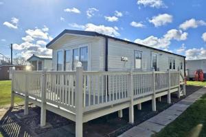 a mobile home with a white fence at Ingoldmells - Ingoldale Park Fantasy Island in Skegness