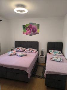 two beds in a bedroom with purple sheets at Apartment Snježana in Crikvenica