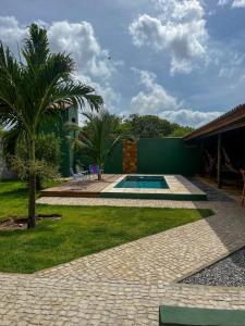 a backyard with a swimming pool and a palm tree at Casa verde in Fortim