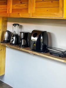 a kitchen counter with various appliances on a shelf at Casa verde in Fortim
