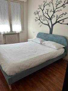 a bedroom with a bed with a tree on the wall at Casa Giulia in Santarcangelo di Romagna +7 photos