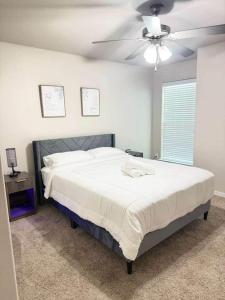 a bedroom with a large bed with a ceiling fan at The West House Cozy-Modern-Spacious in Midland