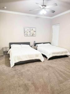 a bedroom with two beds and a ceiling fan at The West House Cozy-Modern-Spacious in Midland