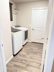 a kitchen with a washer and dryer next to a door at The West House Cozy-Modern-Spacious in Midland +24 photos