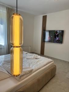 a bedroom with a bed with a large yellow light at Kopalnia soli apartments in Wieliczka