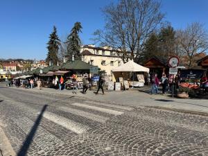 a group of people walking on a street with a market at Kopalnia soli apartments in Wieliczka