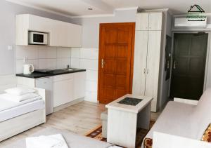 a kitchen with white cabinets and a brown door at Noclegi Jaroszowice in Jaroszowice