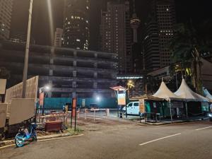 a motorcycle parked on the side of a road with tents at park view Service Apartment near KLCC in Kuala Lumpur
