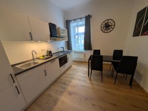 a kitchen with a sink and a table with chairs at Flataid Apartmenthaus Tieschen in Tieschen