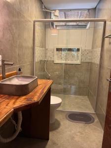 a bathroom with a shower and a sink and a toilet at Chalé Shangri-la in Paraty +14 photos