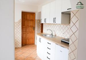 a kitchen with white cabinets and a sink at Noclegi Jaroszowice in Jaroszowice +31 photos