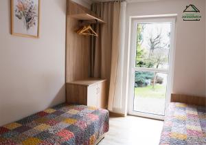 a bedroom with a bed and a window with a door at Noclegi Jaroszowice in Jaroszowice