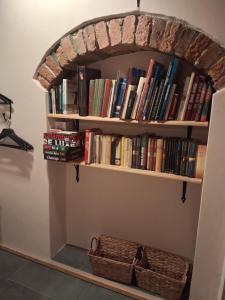 a book shelf filled with books and a basket at Kamienica Marianna in Reszel