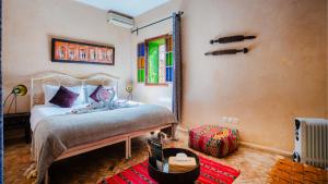 ein Schlafzimmer mit einem Bett und einem Spiegel in einem Zimmer in der Unterkunft Riad Dama & Spa in Marrakesch