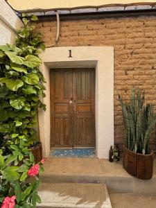 a wooden door of a building with flowers and plants at Casa Díaz Habitacion Diamante in Parras de la Fuente