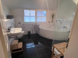 a bathroom with a tub and a sink and a toilet at Ferienhaus Prerow an der Stems in Prerow +20 photos