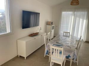a dining room with a table and a kitchen with a tv at Casa vacanza Cipria in Olìa Speciosa
