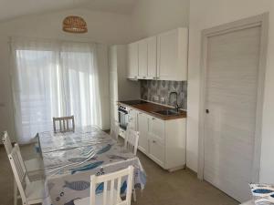 a kitchen with a dining table and a kitchen with a sink at Casa vacanza Cipria in Olìa Speciosa