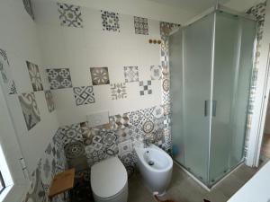 a bathroom with a shower and a toilet and a sink at Casa vacanza Cipria in Olìa Speciosa +9 photos