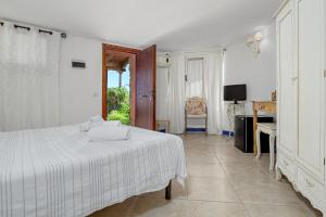 a bedroom with a bed and a desk and a window at Villaggio Marineledda in Santa Marinella +80 photos