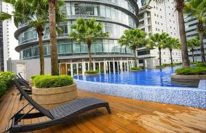 a building with a pool in front of a building with palm trees at park view Service Apartment near KLCC in Kuala Lumpur