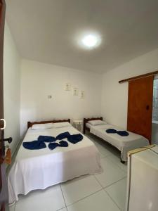 a room with two beds with blue towels on them at Pousada Pedra Furada in Jericoacoara