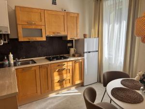 a kitchen with wooden cabinets and a white refrigerator at Kopalnia soli apartments in Wieliczka