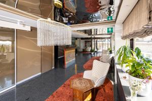 eine Lobby mit weißen Stühlen und einem Kronleuchter in der Unterkunft Hotel Art in Sarajevo