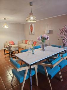 a dining room with a table and blue chairs at Muralha da Barca Apartamentos -Fique no centro do Porto junto a ponte D-Luis IRNAL nº13939 Al,5848 Al, 6419 AL-Chamada para a rede móvel nacional in Porto