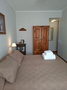 a bedroom with a large bed and a wooden cabinet at Hotel El Descanso in Junín