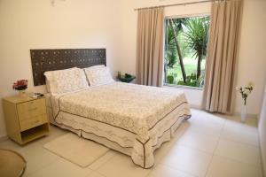 a bedroom with a large bed and a window at Rosa Spa e Pousada in Aparecida de Goiânia +200 photos