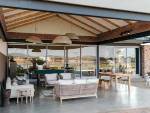 a living room with white furniture and a table at Stroomrivier Lodge in Boshoek