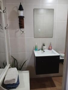 a bathroom with a sink and a mirror and a toilet at Atardecer porteño in Puntarenas