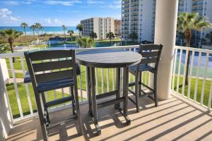 a table and two chairs on a balcony with the ocean at Beachfront Resort with Heated Pool Saida Royale 9039 in South Padre Island