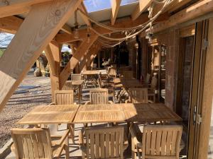 a row of wooden tables and chairs on a building at Lodge at Lochside in Bridgend of Lintrathen