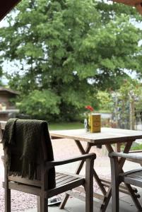 a wooden picnic table with a chair and a box on it at Lodge at Lochside in Bridgend of Lintrathen +7 photos
