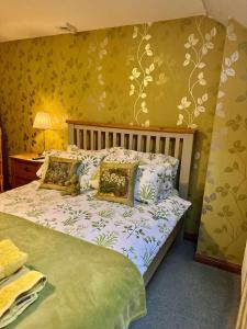 a bedroom with a bed with green and yellow walls at Lodge at Lochside in Bridgend of Lintrathen