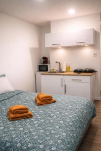 two brown towels sitting on a bed in a kitchen at Petit cocon moderne Cuisine équipée TV WIFI in Roubaix