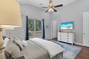 a bedroom with a bed and a ceiling fan at Comal Cottage in Canyon Lake