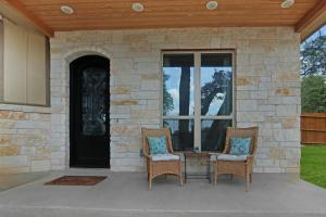two chairs and a table in front of a door at Comal Cottage in Canyon Lake